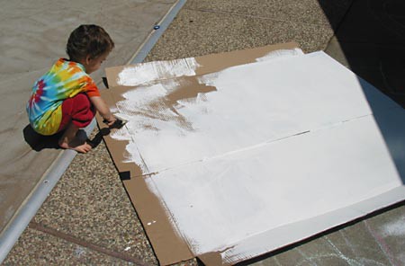 A sheet of cardboard is painted with a layer of white gesso