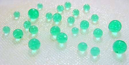 Photo of translucent green spheres of different sizes on a table