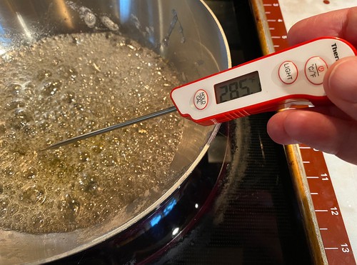 checking temperature of candy with thermometer 