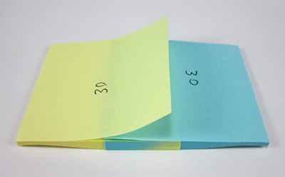Two interleaved sticky note pads