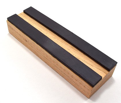 Magnetic strips run along the long edges of a wooden block