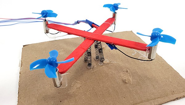 Drone mounted on four springs that are glued to a piece of cardboard