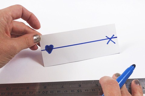  A paper card with two drawn symbols on each side and a straight line going from the left to the right.  