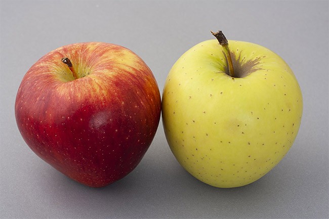 A green apple and a red apple sitting side-by-side. 