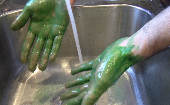 Hands with some paint washed off after rinsing in the sink.