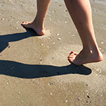 Photo of feet of a person walking on the beach for an activity about sand