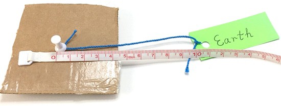 A 10 cm string connects a pushpin with the label 'earth'