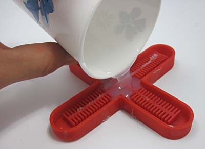 Liquid silicon is poured into a red cross-shaped mold