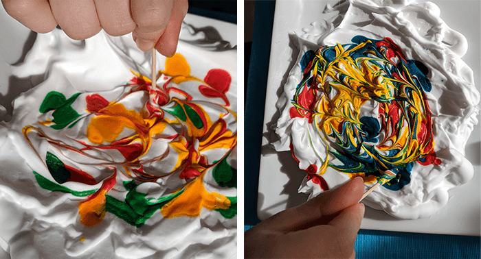 Students hand mixing food coloring on top of shaving cream with a tooth pick as part of a paper marbling science activity