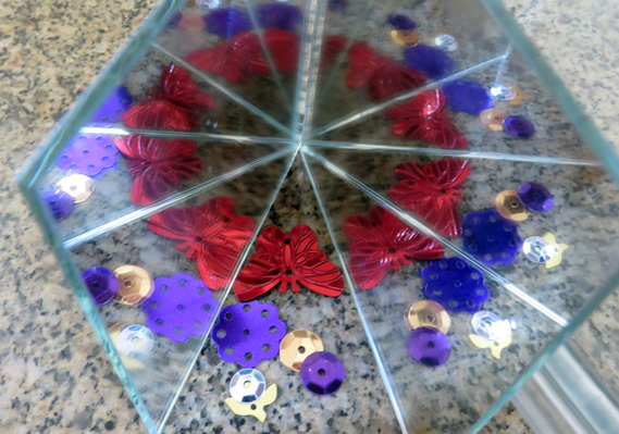 Set of mirrors reflecting small objects in repetition like an infinity mirror or kaleidoscope