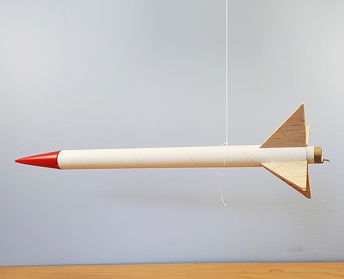 A rocket balanced about its center of mass while hanging from a string