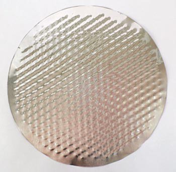 A circle of aluminum from a pie pan with the walls cut off