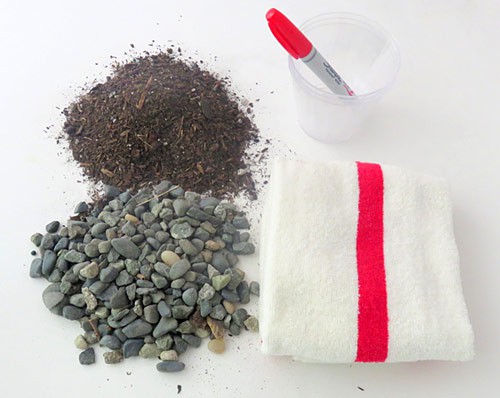 Soil, gravel, a towel, plastic cups and a marker