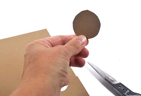 Hand holding a cutout circle from cardstock.