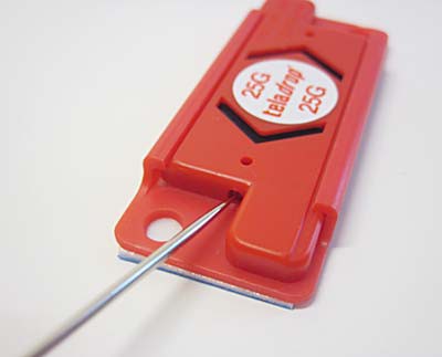 A needle is used to reset an activated shock indicator