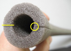 Foam pipe insulation is cut length-wise into two even halves