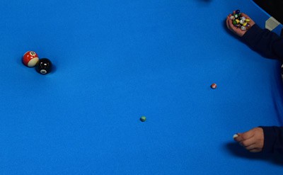 Two billiard balls at the center of a stretched blue sheet