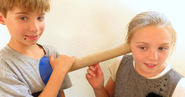 Homeade stethoscope behing used by one student to listen to the heart beat of another student