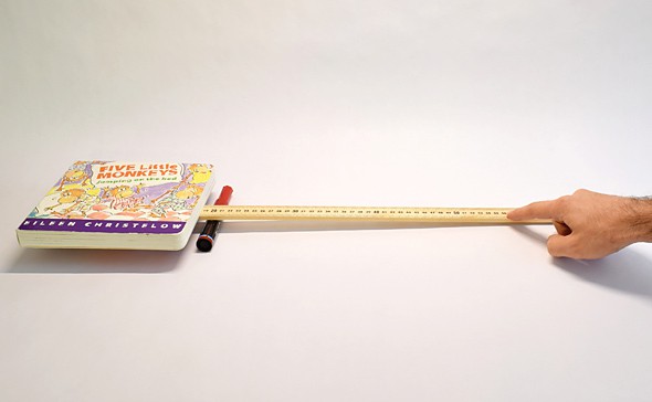 A yard stick and a marker form a lever that lifts a book with the effort of one finger