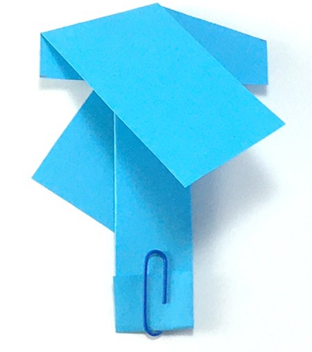 Folded paper helicopter with a paperclip keeping the bottom flap in place. 