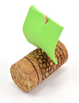 A sheet of green foam covers the top of a toothpick stuck into the side of a cork cylinder