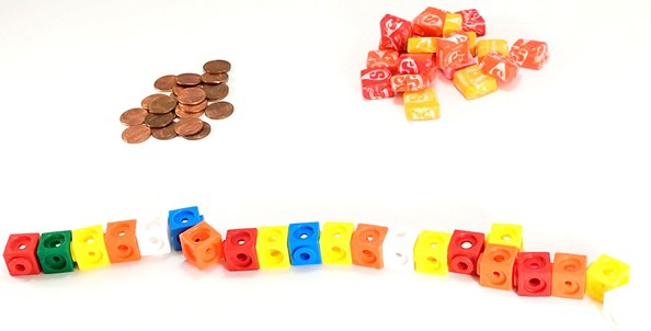 Stack of 21 pennies, 21 cubed candies and 21 small blocks.